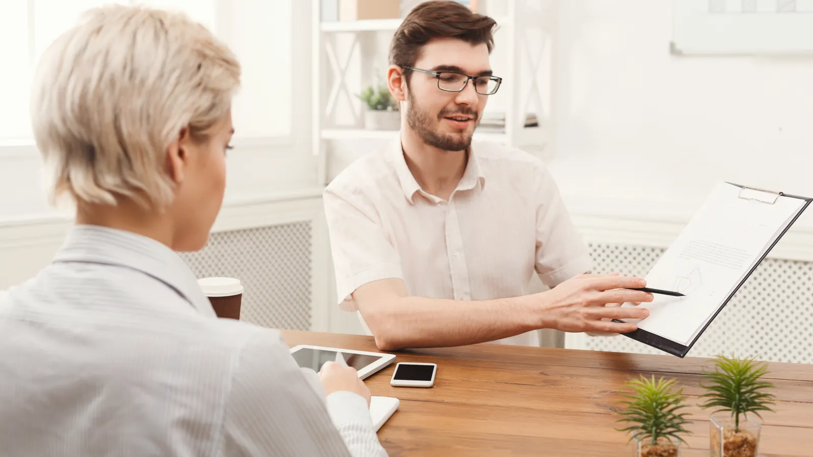 Adviser explaining documents to a client at a desk