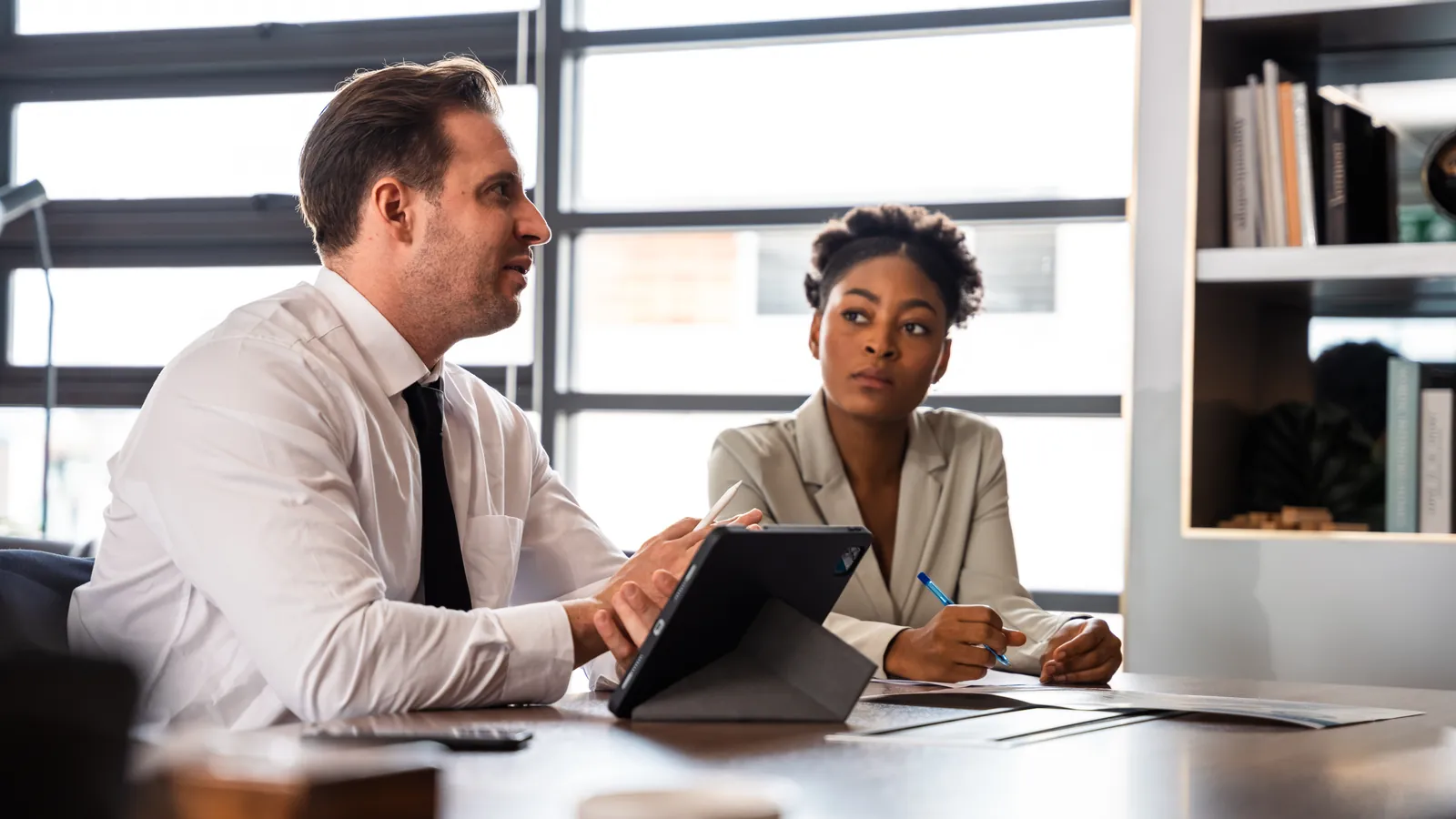 Business consultant discussing strategy and figures on a tablet with a founder