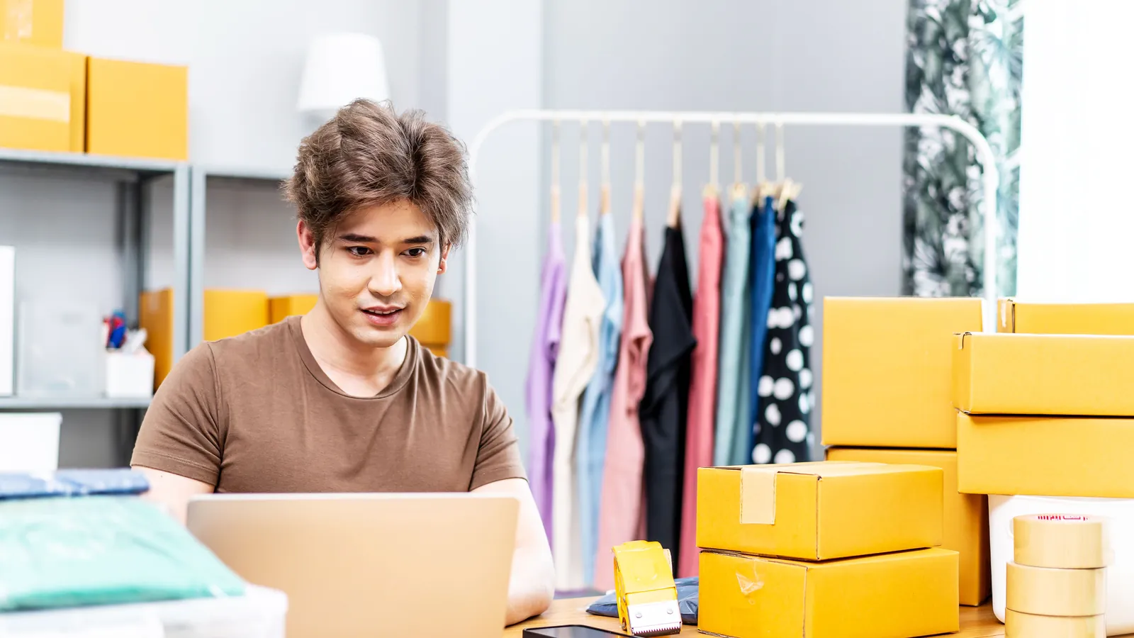 Jugendlicher arbeitet am Laptop an seinem kleinen Online-Geschäft