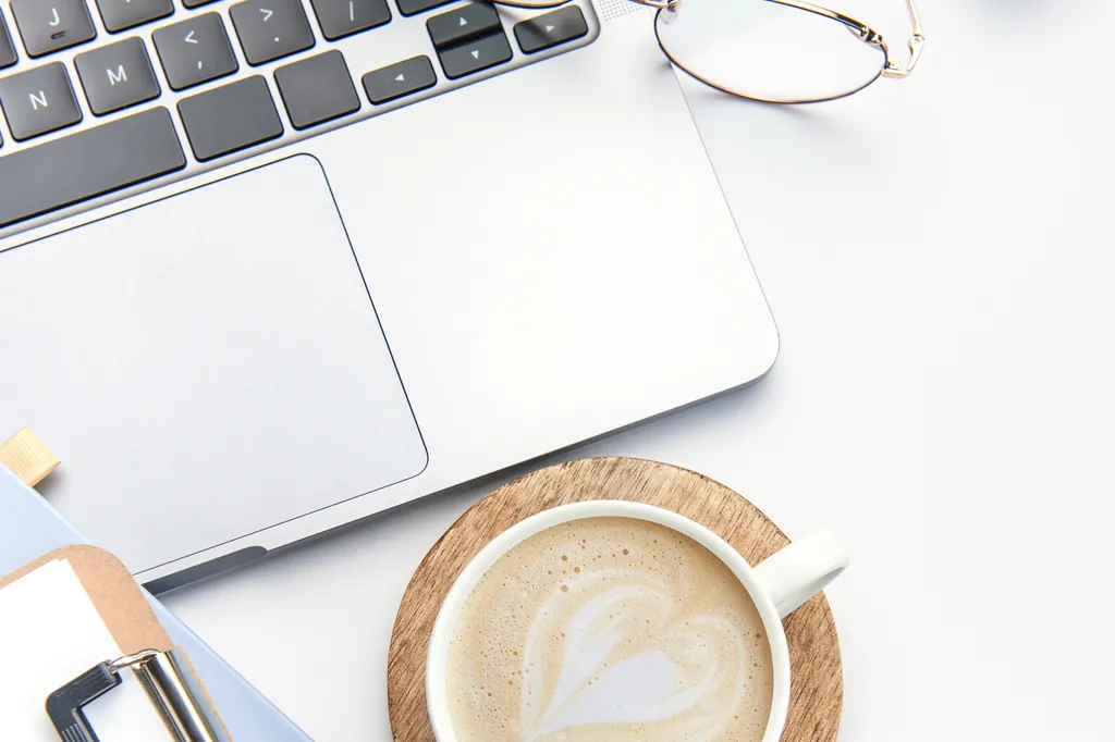 Laptop, Kaffee und Unterlagen auf dem Schreibtisch – der Arbeitsalltag in der Selbstständigkeit