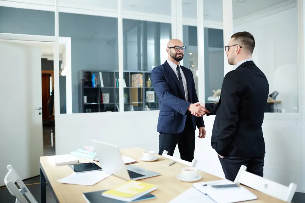 Arbeitgeber und neue Mitarbeiterin besprechen den Einstellungsprozess im Büro