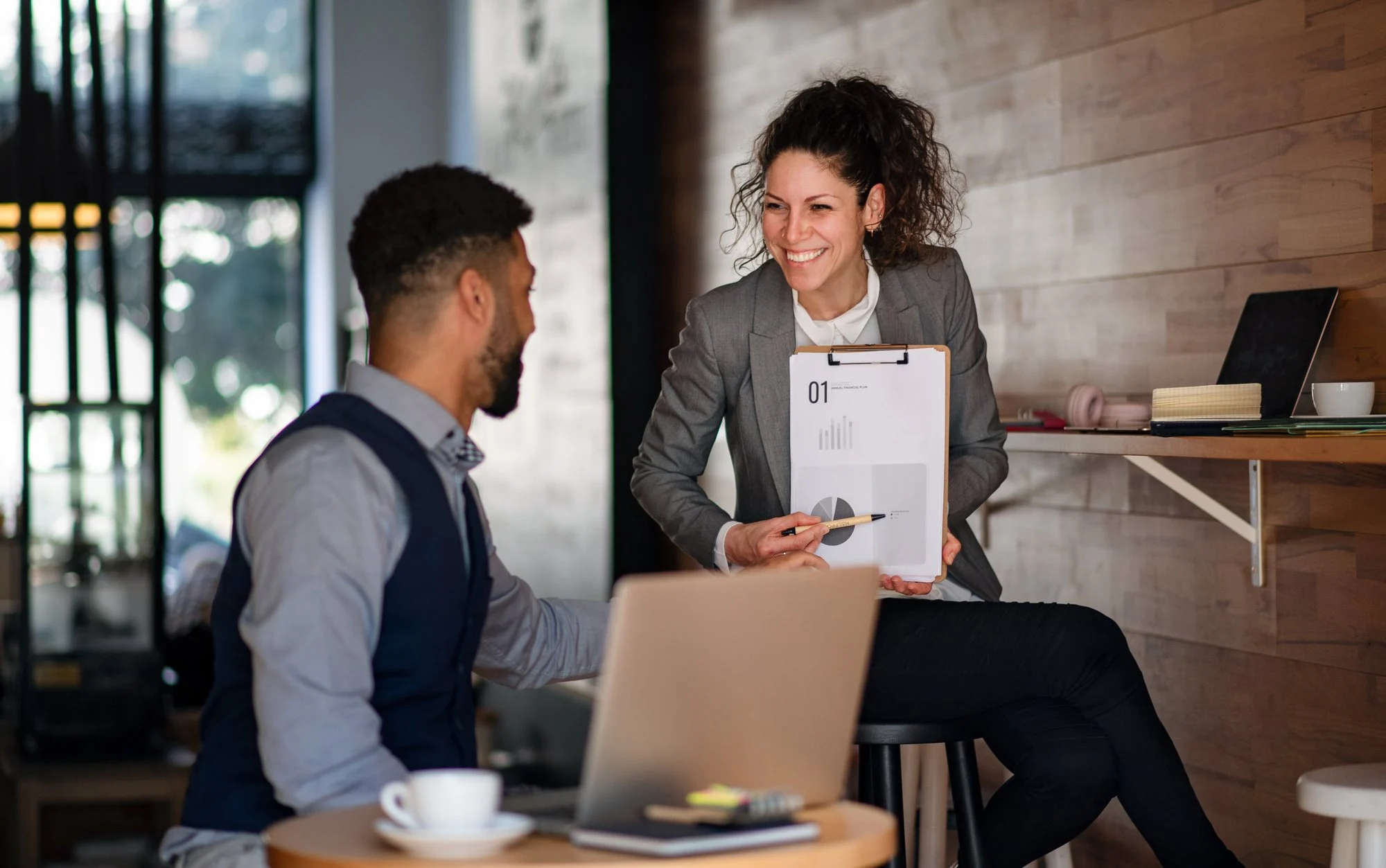 Beraterin und Gründer besprechen die Antragsunterlagen im Büro