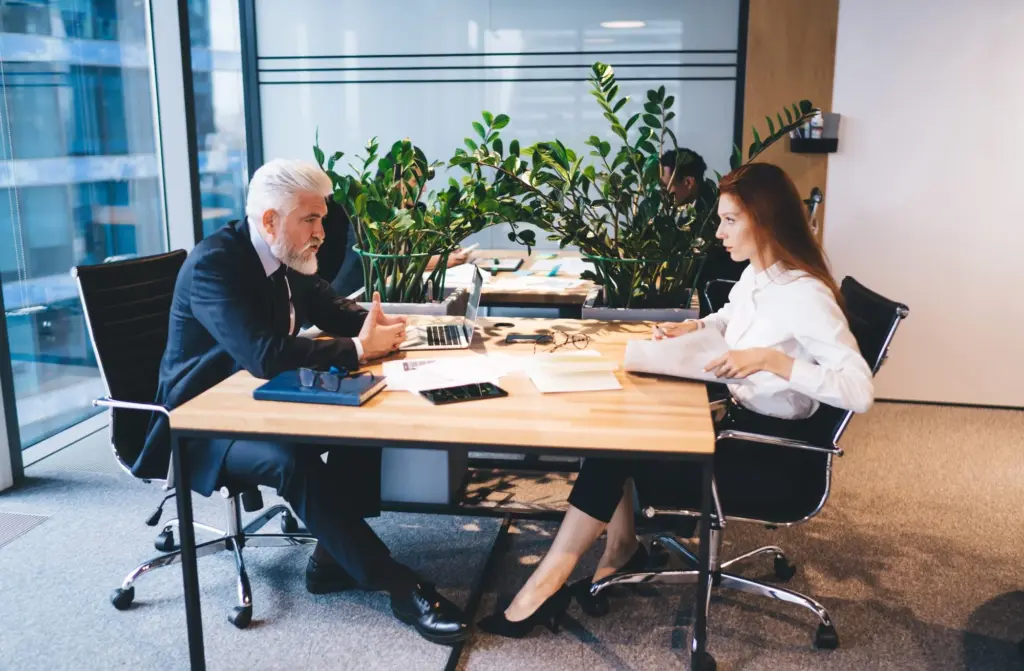 Berater und Gründerin besprechen Unterlagen im Büro